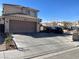 Two-story home with a tile roof, attached two-car garage, and a spacious driveway on a sunny day at 2291 Grannis Ln, Las Vegas, NV 89104