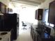 A kitchen area with dark cabinets, stainless steel sink, and tile flooring at 2313 E Mcwilliams Ave, Las Vegas, NV 89101