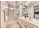 Well-lit bathroom with a large mirror, double sinks, glass enclosed shower, and decorative lighting at 2702 Grand Forks Rd, Henderson, NV 89052