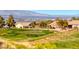 Golf course view featuring lush greenery, desert landscaping, and city views in the distance at 2702 Grand Forks Rd, Henderson, NV 89052