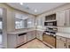 Functional kitchen with updated appliances, light-colored cabinets, and an open view to the dining area at 2702 Grand Forks Rd, Henderson, NV 89052