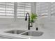 Close-up of a modern kitchen sink with stainless steel fixtures and a bright window with a view at 2728 Goldcreek St, Henderson, NV 89052