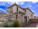 Two-story home featuring a charming stone entryway and lush, desert-friendly landscaping at 3009 Little Crimson Ave, North Las Vegas, NV 89081