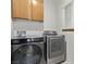 Convenient laundry room with a modern washer and dryer set and wood cabinets at 3009 Little Crimson Ave, North Las Vegas, NV 89081