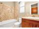 Elegant bathroom featuring granite accents, a soaking tub, and stylish vanity with wood cabinets at 32 Hunting Horn Dr, Las Vegas, NV 89135