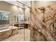 A modern bathroom featuring a glass shower, dual vanities, and a soaking tub at 32 Hunting Horn Dr, Las Vegas, NV 89135