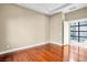 Bright bedroom featuring hardwood floors and a modern glass-paneled door leading to an outdoor space at 32 Hunting Horn Dr, Las Vegas, NV 89135