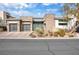 Contemporary home featuring a stone facade, tinted glass privacy screen, and desert landscaping at 32 Hunting Horn Dr, Las Vegas, NV 89135