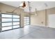 Spacious garage with gray epoxy flooring and glass panel doors, featuring ample space for vehicles and storage solutions at 32 Hunting Horn Dr, Las Vegas, NV 89135