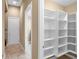 Hallway with modern shelving units and bright lighting, next to a laundry room and adjacent rooms with seamless transition at 32 Hunting Horn Dr, Las Vegas, NV 89135