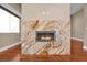 Marbled fireplace with modern fireplace hardware over hardwood flooring at 32 Hunting Horn Dr, Las Vegas, NV 89135