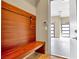 A mudroom featuring a built-in bench with coat hooks adjacent to an open garage with glass panel doors at 32 Hunting Horn Dr, Las Vegas, NV 89135