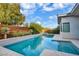 Backyard pool with clear blue water and a modern design, framed by lush greenery and a sleek, contemporary house at 32 Hunting Horn Dr, Las Vegas, NV 89135