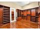 Beautiful walk-in closet featuring custom built-in shelving, cabinets, and hardwood floors at 32 Hunting Horn Dr, Las Vegas, NV 89135