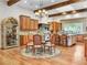 Bright kitchen features wooden cabinets, beams, chandelier, hardwood floors and island at 330 Rancho Cir, Las Vegas, NV 89107