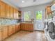 Clean and bright laundry room featuring ample cabinet space, tile backsplash and modern washer and dryer at 330 Rancho Cir, Las Vegas, NV 89107