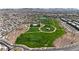 Expansive aerial view showcasing a community with green spaces, a pool area, and residential neighborhoods at 371 Silva Pl, Henderson, NV 89011