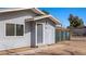 Detailed view of the entrance, showcasing its gray door, siding, and a green chain-link fence at 432 Bonelli Ave, Overton, NV 89040