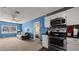 Open-concept living room next to kitchen features blue walls, carpet, and couch at 432 Bonelli Ave, Overton, NV 89040