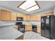 Well-lit kitchen featuring matching black appliances and neutral countertops with light wood cabinetry at 4655 Gold Dust Ave # 139, Las Vegas, NV 89120