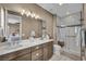 Modern bathroom featuring double sinks, a large mirror, and a glass-enclosed shower with stylish tile work at 500 Pear Lake St, Las Vegas, NV 89138