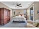 Cozy bedroom features an armoire, plush carpet, ceiling fan, and door to the outside at 500 Pear Lake St, Las Vegas, NV 89138