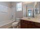 Well-lit bathroom with a tub, toilet, and vanity with a large mirror at 5596 Danforth Ave, Las Vegas, NV 89141