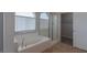 Bright bathroom showcasing soaking tub, glass enclosed shower, and walk-in closet at 5596 Danforth Ave, Las Vegas, NV 89141