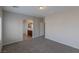 Bedroom with neutral carpet, gray walls, and an archway leading to the bathroom at 5596 Danforth Ave, Las Vegas, NV 89141