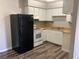 A functional kitchen featuring white cabinetry, a black refrigerator and modern appliances at 575 S Royal Crest Cir # 13, Las Vegas, NV 89169