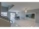 Open living room with tile floors, a modern chandelier, and stairs to the second floor at 6250 W Flamingo Rd # 7, Las Vegas, NV 89103