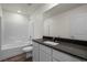 Clean bathroom featuring dark countertop, white cabinets, a tub and shower at 6257 Blood Lily Ave, Las Vegas, NV 89122