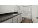 Bathroom featuring dark countertop, white cabinets, and enclosed tiled shower and tub at 6257 Blood Lily Ave, Las Vegas, NV 89122