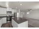 Open concept kitchen with white cabinets, gray countertops, stainless appliances, and seamless flow to living area at 6257 Blood Lily Ave, Las Vegas, NV 89122