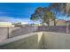 Fenced backyard with raised concrete block wall, trees, and low-maintenance landscaping at 691 Anne Ln # 0, Henderson, NV 89015