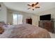 Well-lit main bedroom boasts a ceiling fan, TV, and access to a private balcony at 691 Anne Ln # 0, Henderson, NV 89015