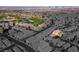 An aerial perspective showcases a neighborhood bordering a golf course and pond against the monochromatic cityscape at 746 Royal Course Ct, Las Vegas, NV 89148