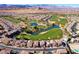 Breathtaking aerial view of a golf course community with a winding course, serene lakes, and mountain backdrop at 746 Royal Course Ct, Las Vegas, NV 89148