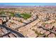 An aerial view showcases a residential area, highlighting neatly arranged homes and a lush golf course with a lake at 746 Royal Course Ct, Las Vegas, NV 89148