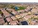 An aerial view reveals an expansive neighborhood adjacent to a golf course with a water feature and numerous residences at 746 Royal Course Ct, Las Vegas, NV 89148