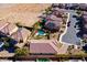 An overhead shot of a home with desert landscape and a backyard that features a pristine pool and lush greenery at 746 Royal Course Ct, Las Vegas, NV 89148