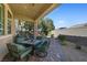 A cozy covered patio features outdoor seating with green cushions and a brick paver floor at 746 Royal Course Ct, Las Vegas, NV 89148