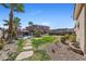 Landscaped backyard with grass, desert foliage, and a fenced pool area at 746 Royal Course Ct, Las Vegas, NV 89148