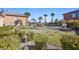 Landscaped backyard with grass, desert foliage, and a fenced pool area at 746 Royal Course Ct, Las Vegas, NV 89148