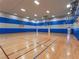 Spacious indoor basketball court with hardwood floors, blue accents, and well-lit with multiple overhead lights at 746 Royal Course Ct, Las Vegas, NV 89148