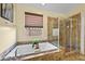 Inviting bathroom featuring a large soaking tub and step-in shower with decorative tile at 746 Royal Course Ct, Las Vegas, NV 89148