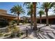 Picturesque courtyard surrounded by tall palm trees, brick pavers, and manicured landscaping under a sunny sky at 746 Royal Course Ct, Las Vegas, NV 89148