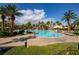 Beautiful community pool with palm trees, lounge chairs, and sun umbrellas under a blue sky at 746 Royal Course Ct, Las Vegas, NV 89148