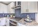 Modern kitchen showcasing stainless steel appliances, granite countertops, and blue backsplash at 7808 Alola Springs Ln # Lot 2, North Las Vegas, NV 89084