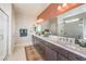 Modern bathroom featuring a double vanity, quartz countertop, walk-in shower, and a large mirror at 7812 Alola Springs Ln # Lot 1, North Las Vegas, NV 89084